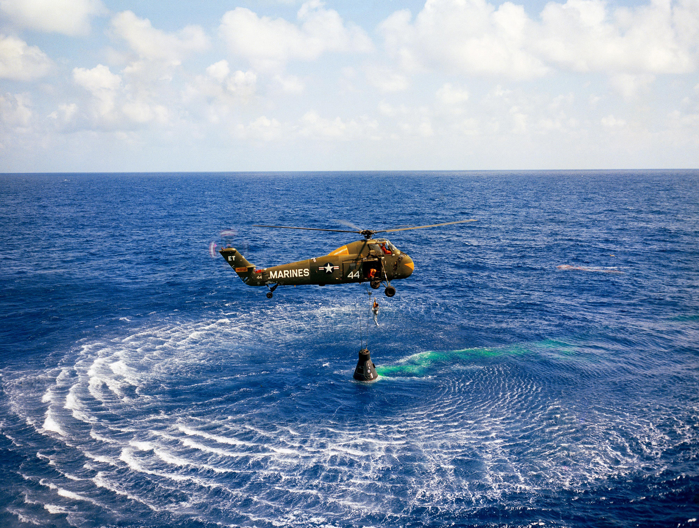 A Marine helicopter picks up Mercury astronaut Alan Shepard and his Freedom 7 capsule in the Atlantic Ocean after his first American sub-orbital flight on May 5, 1961. Engineers said the spacecraft was in such great shape it could be reused. Doctors said Shepard could be used again too. Only 11 minutes after landing, he was onboard the U.S. Navy carrier Lake Champlain, where he took a congratulatory phone call from President Kennedy. (NASA)