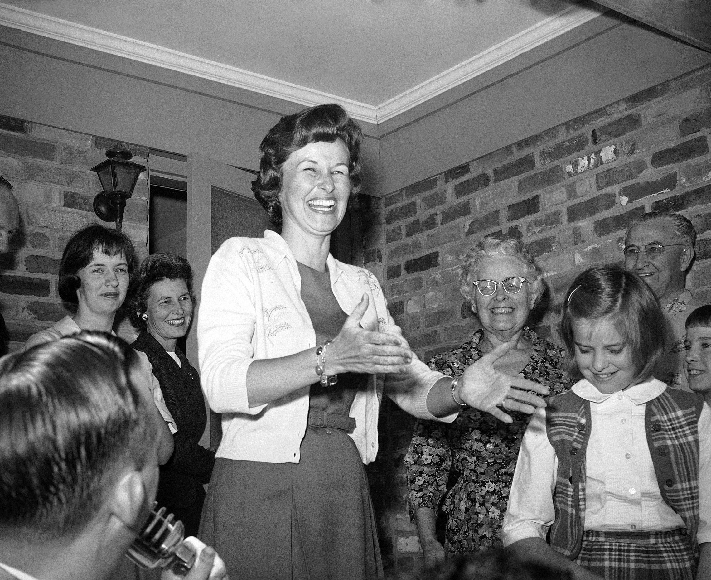 Almost beside herself with glee, Mrs. Alan Shepard, left, wife of the famous astronaut, as she appeared on the front porch of her Virginia Beach home after the word had come that her husband was safe. With her are her mother and father, Mr. and Mrs. Russell Brewer, Alice Williams, a niece, and her daughter Juliana in Norfolk on May 5, 1961. (AP Photo/Bill Allen)